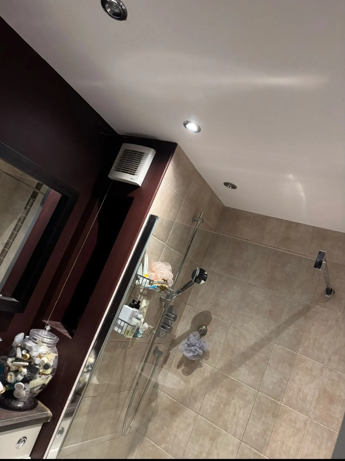Beige shower wall tiles, handheld shower and glass screen in the completed Ewerby bathroom