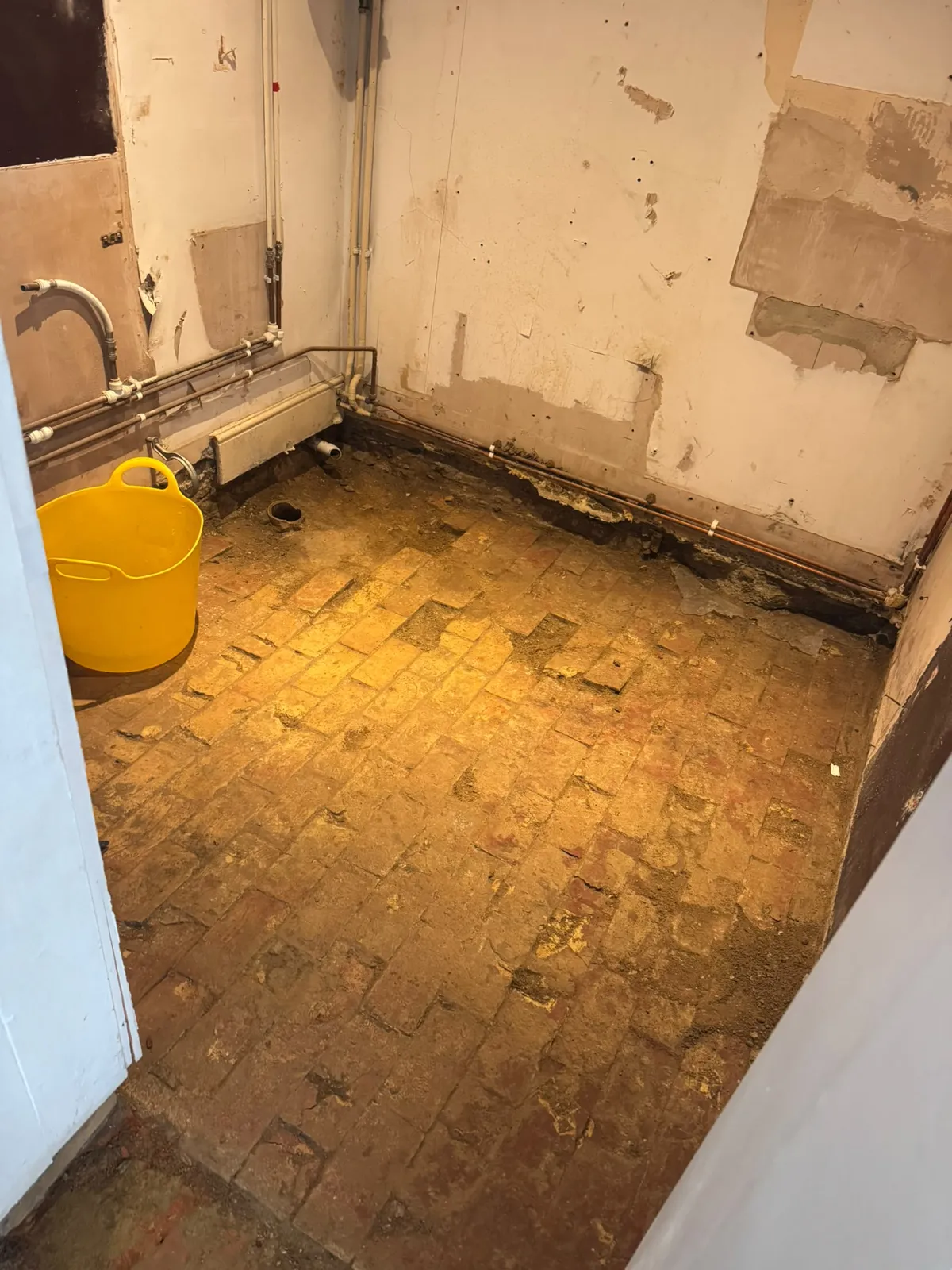 Existing brick floor layer exposed after rubble removal in Ewerby