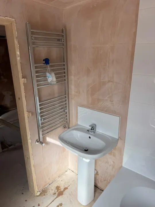 New basin and chrome towel radiator in the replastered Holbeach bathroom