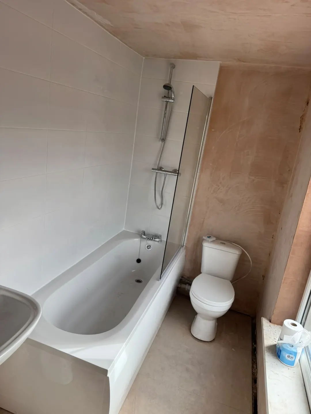 New bath, shower, glass screen and wall tiles in the Holbeach flat before decoration