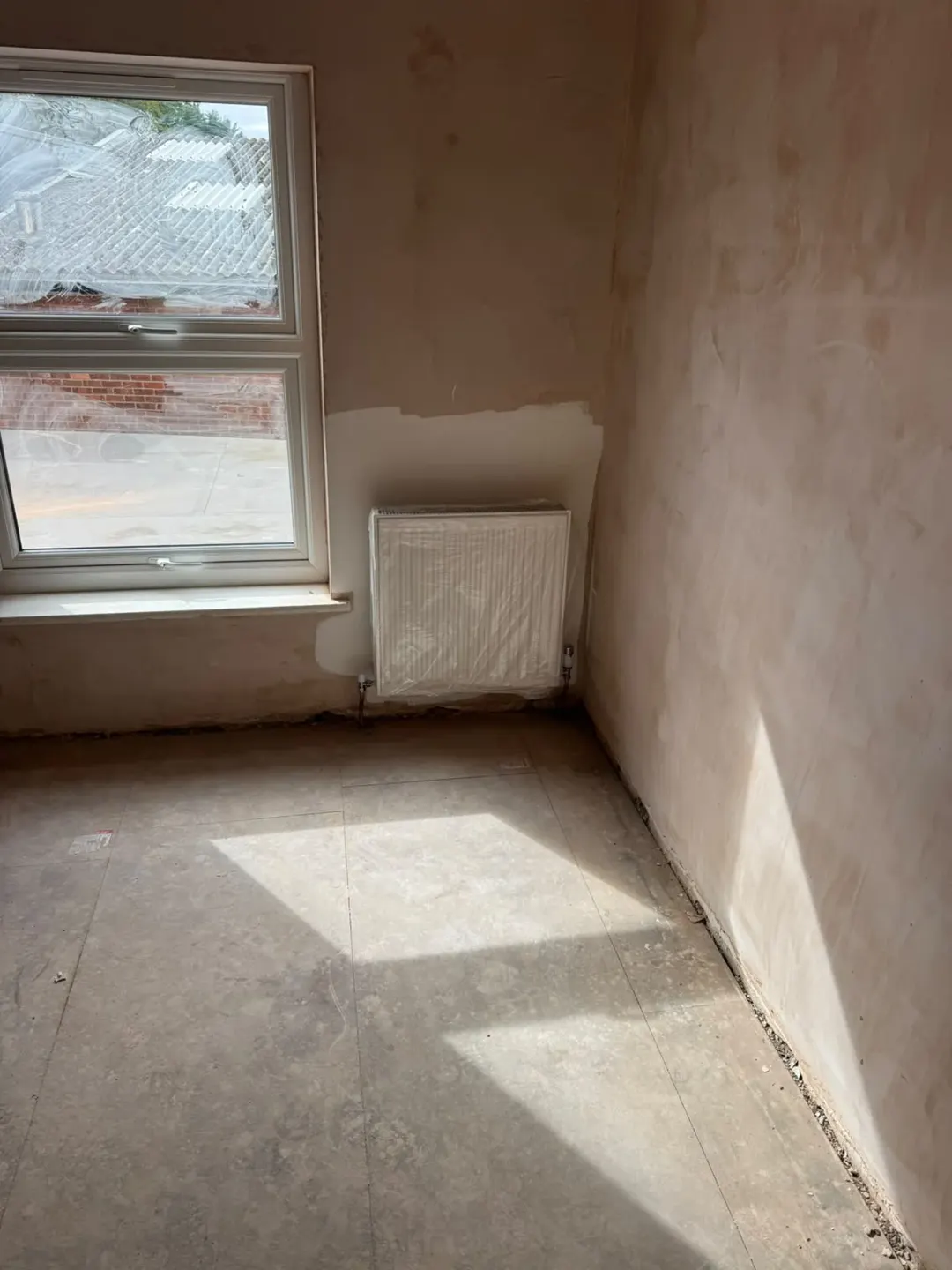 New radiator and replastered walls in the Holbeach flat before final decoration