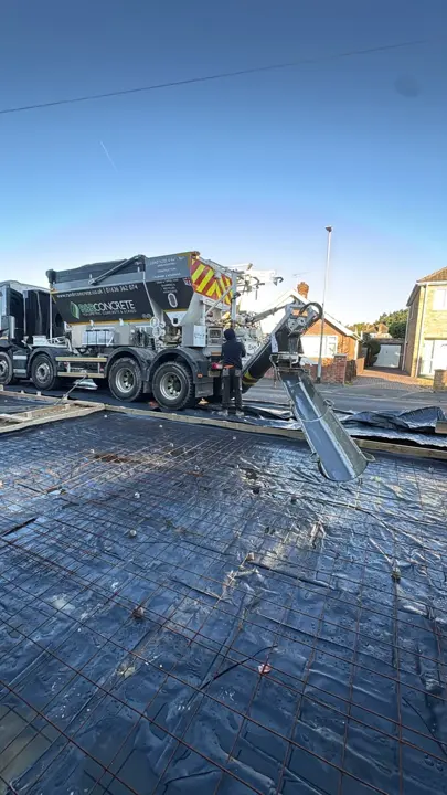 Steel reinforcement mesh over sheeting with a concrete delivery chute at the Lincoln project