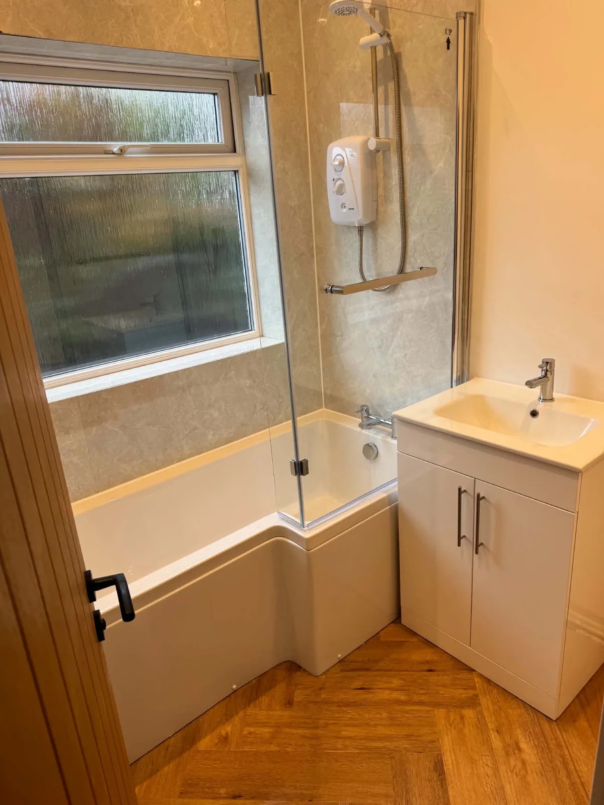 Refurbished Bassingham bathroom with a bath, shower screen and vanity basin