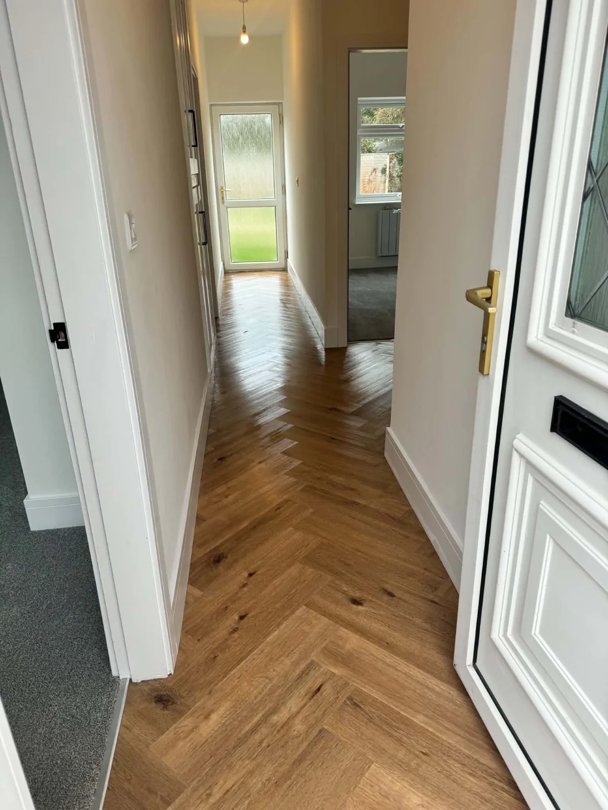 Hallway with timber doors and herringbone-pattern flooring in Bassingham