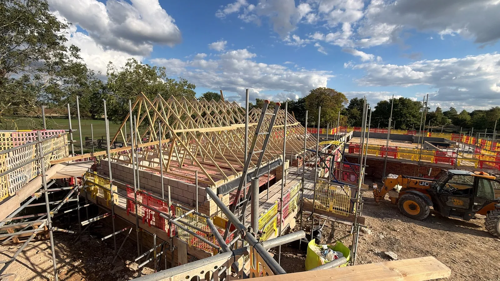 Timber garage roof trusses above masonry walls and scaffolding in Leasingham