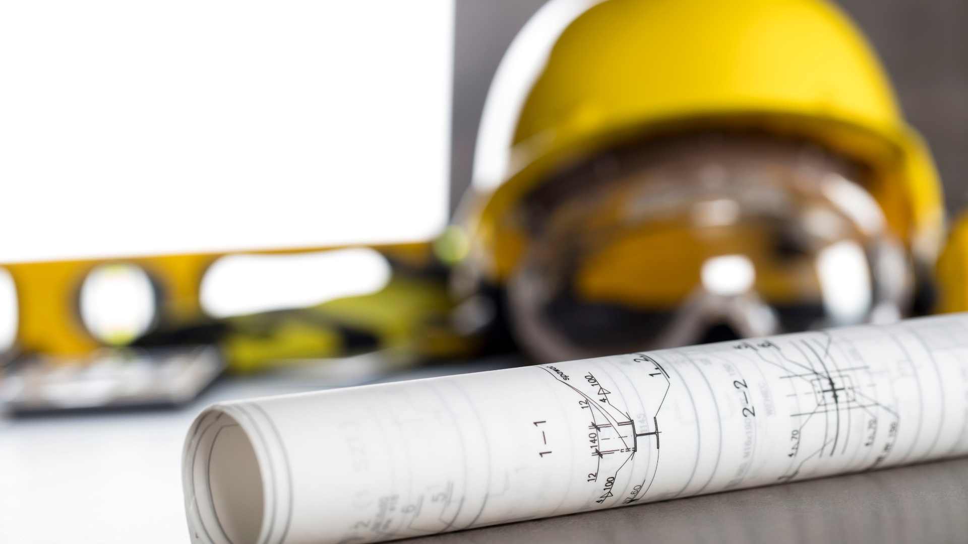 Construction blueprints with hard hat and safety glasses
